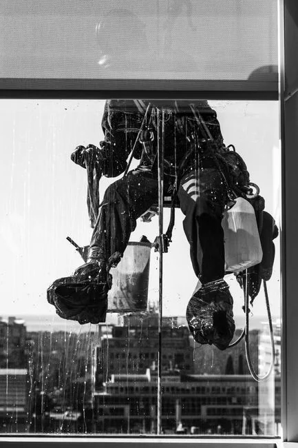 Vue latérale d’un jeune homme d’origine ethnique en uniforme nettoyant le sol avec une serpillière pendant qu’il travaille dans un restaurant au style rétro